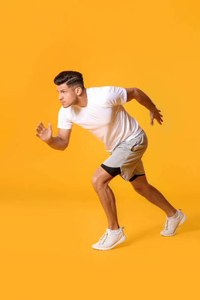 Sporty male runner on color background - Foto, afbeelding
