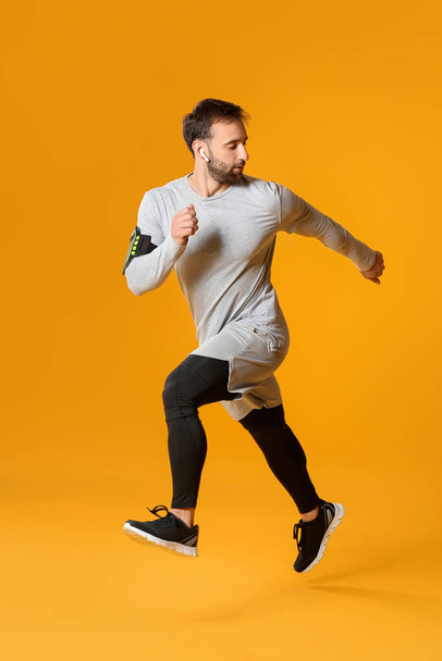 Sporty male runner on color background - Photo, Image