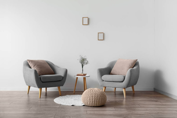 Интерьер современной комнаты с креслами, столом и пуфом - Фото, изображение
