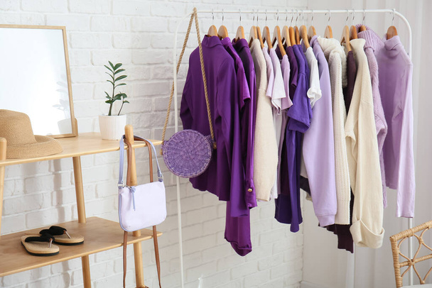 Rack with clothes near white brick wall - Photo, Image
