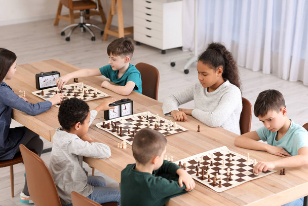 Little children playing chess during tournament in club - Foto, Imagen