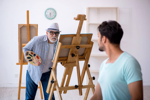 Vecchio pittore e giovane modello maschile allo studio - Foto, immagini