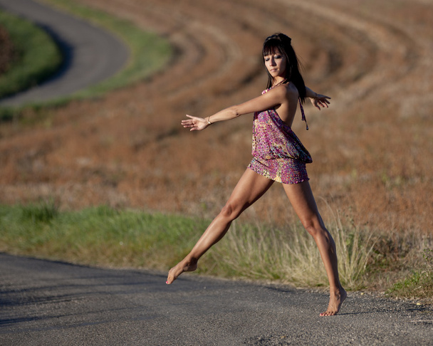 Femme traversant gracieusement une route de campagne
 - Photo, image