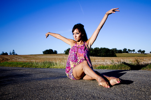 Витончена танцівниця сидить на асфальті
. - Фото, зображення