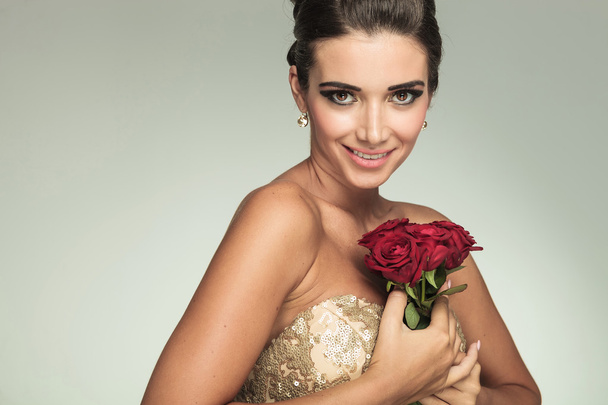 Hymyilevä nainen pitelee ruusuja
 - Valokuva, kuva