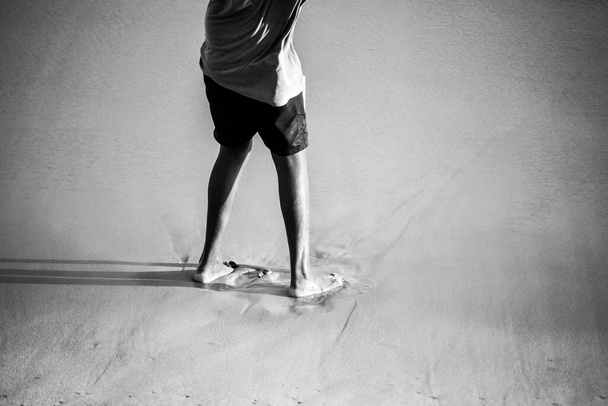 Salvador, Bahia, Brésil - 26 septembre 2021 : Partie inférieure d'une personne debout sur le sable de la plage. Salvador, État de Bahia, Brésil. - Photo, image