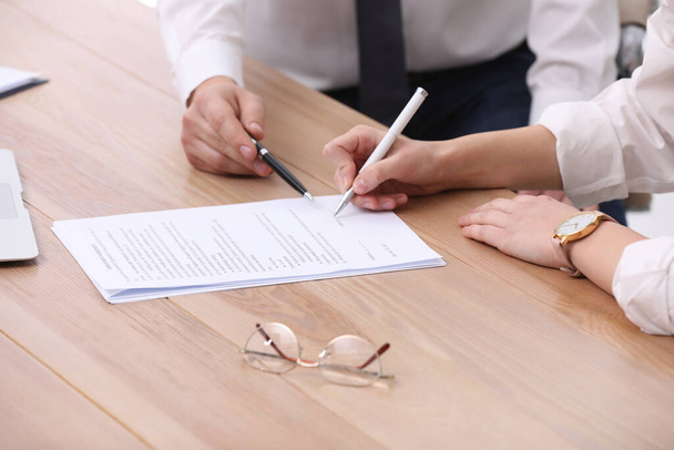 Businesspeople signing contract at wooden table, closeup - Фото, изображение