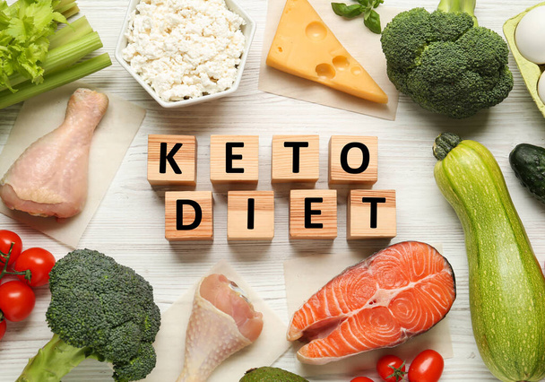 Cubes with phrase Keto Diet and different fresh products on white wooden table, flat lay - Фото, зображення