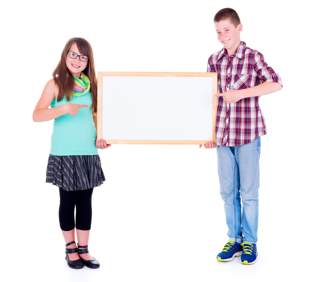 Boy and girl pointing on empty board  - Фото, изображение
