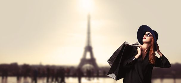 Femme rousse avec des sacs à provisions sur fond parisien
. - Photo, image