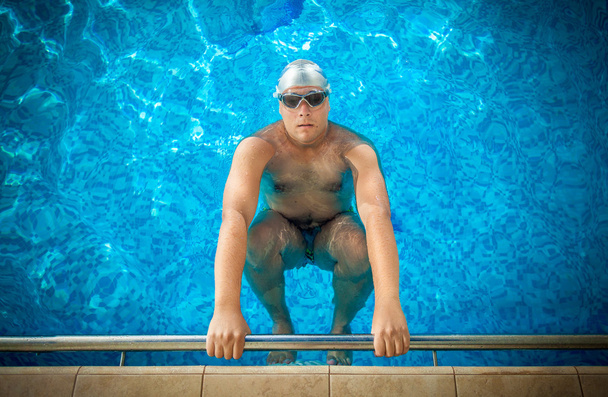male athlete holding on edge of swimming pool and preparing to s - Photo, Image