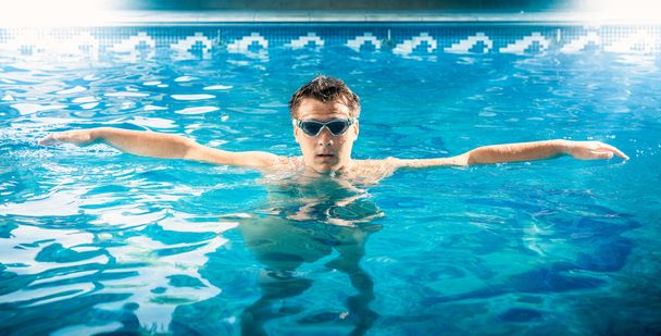 jovem nadador do sexo masculino respirando e relaxando na piscina
 - Foto, Imagem
