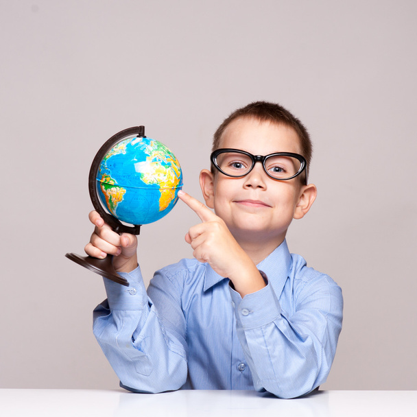 Portrait of a little boy holding a globe. Travel concept - Foto, imagen