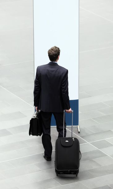 Empresario que elige delante de un cartel con maleta y carro
 - Foto, Imagen