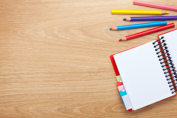 Table de bureau avec bloc-notes vierges et crayons colorés
 - Photo, image
