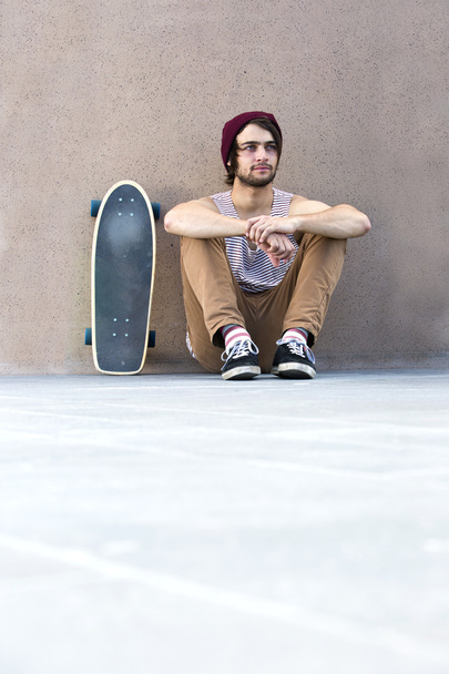 Skateboarder sitting on concrete floor - Foto, immagini