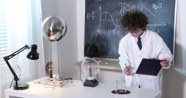 Schooljongen experimenteert met natuurkunde. Jonge student doet natuurkunde experiment in de klas - Video