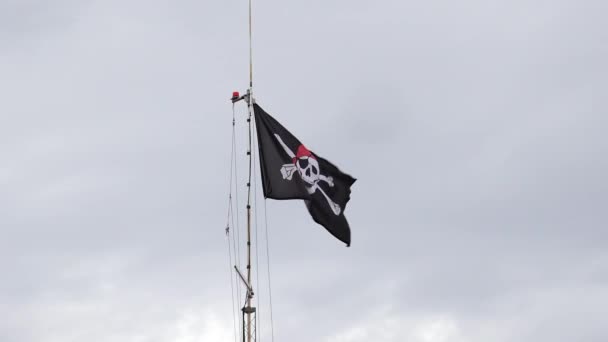 嵐の曇り空に隔離された船マストの海賊旗。海賊の概念。人はいない。スペースのコピー - 映像、動画
