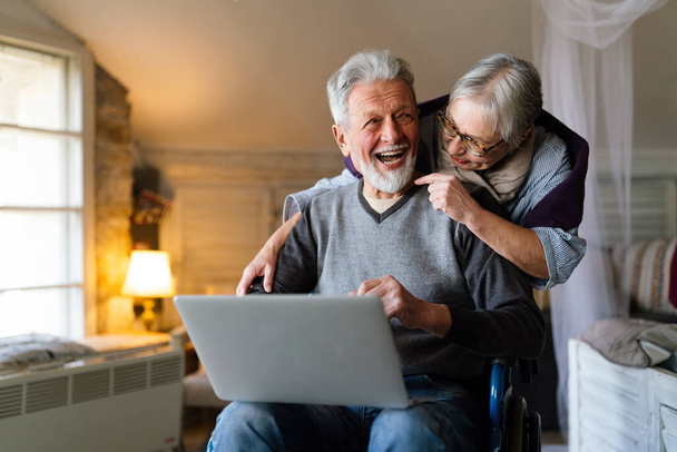 Happy senior couple using laptop at home and having fun together. Technology people concept - Foto, Imagem