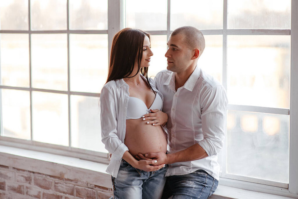 happy family. a pregnant woman and a man in denim. fashionable and comfortable clothes for the family. the happiness of parenthood. social programs to support young families. - Fotografie, Obrázek
