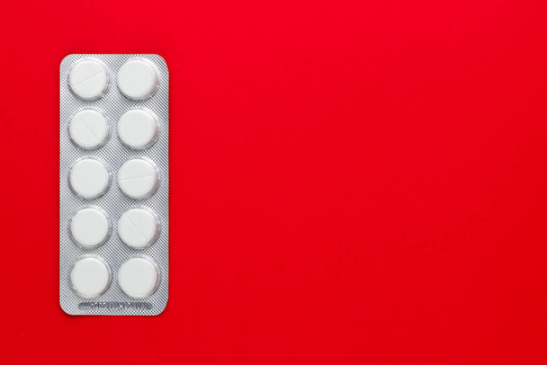 pills and tablets on red background. top view. - Foto, Bild