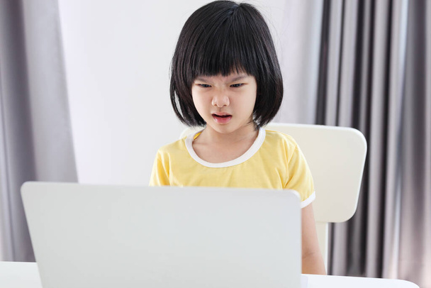 kleine asiatische Mädchen studieren online mit Laptop-Computer zu Hause - Foto, Bild