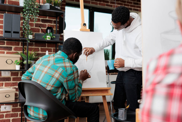Африканский учитель-американец помогает студенту с проектом рисования - Фото, изображение