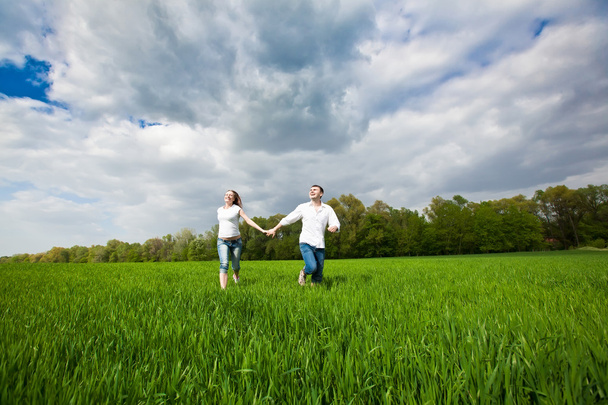 Happy Couple running on a grass - Fotó, kép