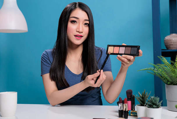 Social media influencer houden make-up palet tonen op camera - Foto, afbeelding