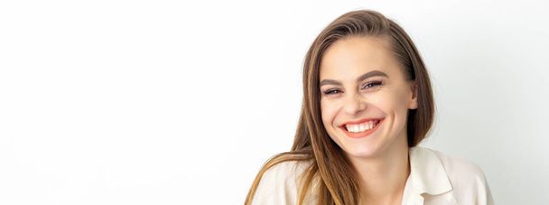 Beauty concept of woman. Portrait of a happy charming shy smiling young caucasian woman with long brown hair posing and looking at the camera over white background - Photo, Image