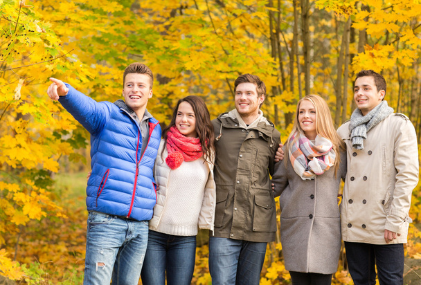 group of smiling men and women in autumn park - Foto, Bild