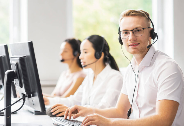 Team of professional support staff working in the office. Colleagues in the workplace solve customer problems. The concept of a call center and customer support. - 写真・画像