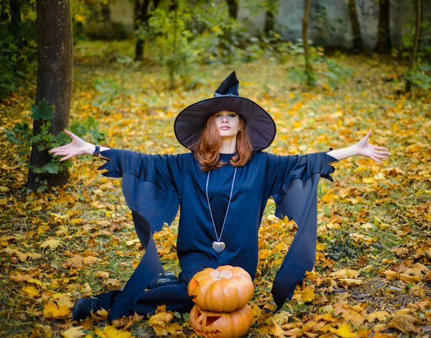 Halloween, girl in witch dress with pumpkin - Photo, Image