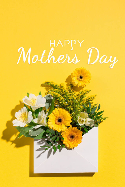 Joyeux concept de fête des mères. Carte de vœux festive avec fleurs printanières blanches et jaunes sur fond jaune vif. Ombres, lumière du soleil. Vue du dessus. - Photo, image