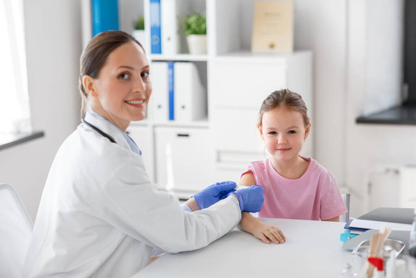 female doctor and little girl patient at clinic - Foto, Imagem