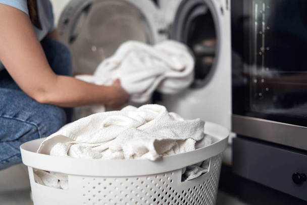 Крупним планом біла жінка робить прання вдома
  - Фото, зображення