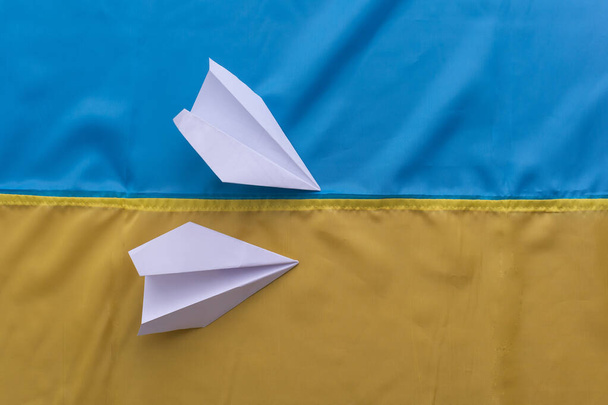 avião de papel no fundo da bandeira da Ucrânia - Foto, Imagem