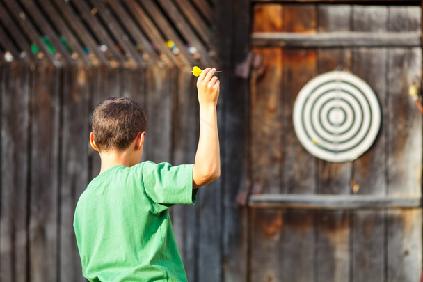 Boy playing darts outdoor - Fotó, kép