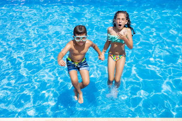 İki küçük çocuk havuza atlıyor. - Fotoğraf, Görsel