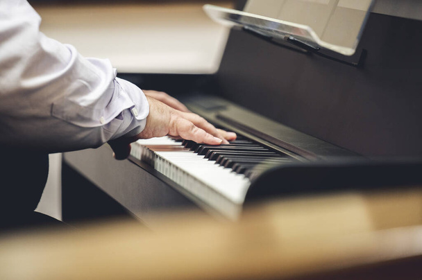 close-up of a man's hands playing a piano keyboard - Valokuva, kuva
