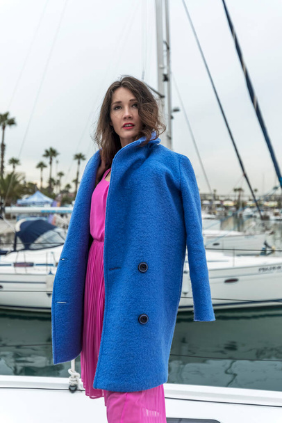 Young woman is posing on a boat at the yacht marina - Foto, immagini