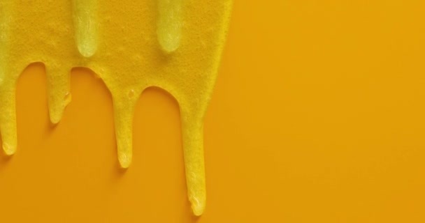 Крем жидкий гель сыворотка стекает вниз на желтую текстуру, макияж и косметический фон, кожа или продукт для волос - Кадры, видео