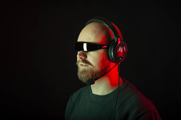 Ciclop güneş gözlüğü takan ciddi sakallı adam kulaklık takıyor.. - Fotoğraf, Görsel