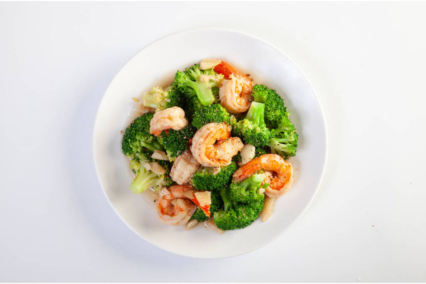 Stir fried broccoli and shrimp on a white background - Valokuva, kuva