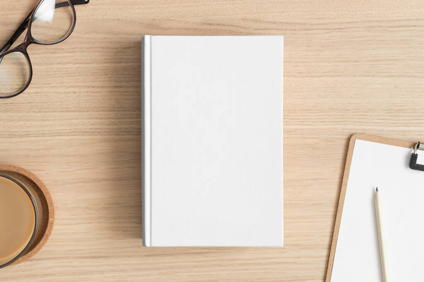 Mockup livro branco com acessórios de espaço de trabalho na mesa de madeira. - Foto, Imagem