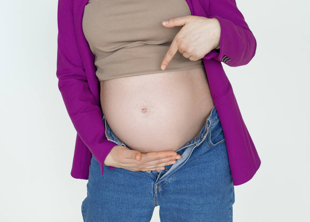 Közelkép, terhes has Terhes nő mutatja ujját, felismerhetetlen terhes nő gyermeket vár, fiatal boldog anya - Fotó, kép