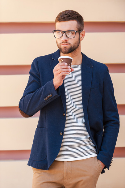 Young man in smart jacket holding coffee cup - Фото, изображение