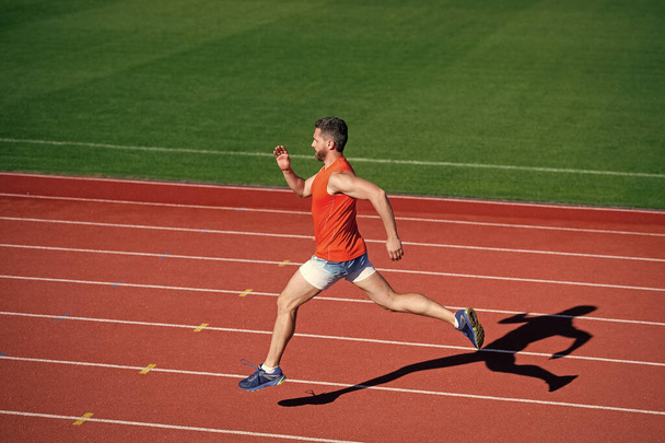 outdoor stadium sprint. physical training. athletic guy run. challenge and competition. - 写真・画像