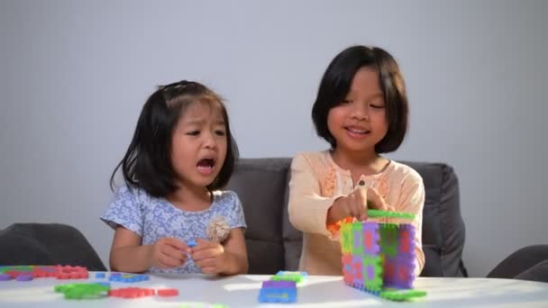 Cute Asian sister same pregnant siblings playing with colorful toy ABC jigsaw, Kids play with educational toys for brain development and imagination. Creative playing of kid development concept - Footage, Video