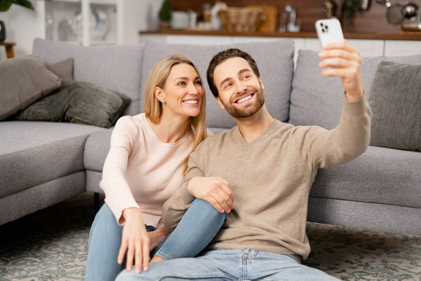 Beautiful girlfriend and handsome boyfriend looking at the selfie cam and posing, making content - Foto, imagen